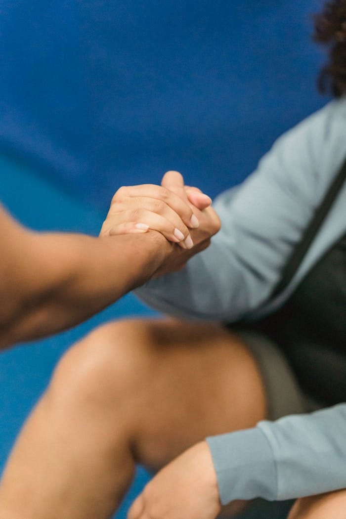 Anonymous couch supporting obese woman resting on floor during training in gym